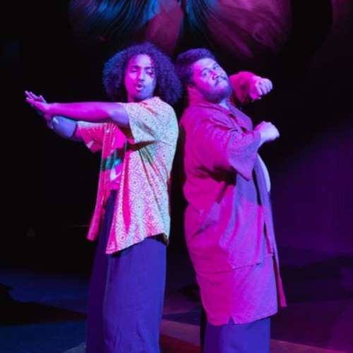 An image of two men standing back-to-back with a neon purple background