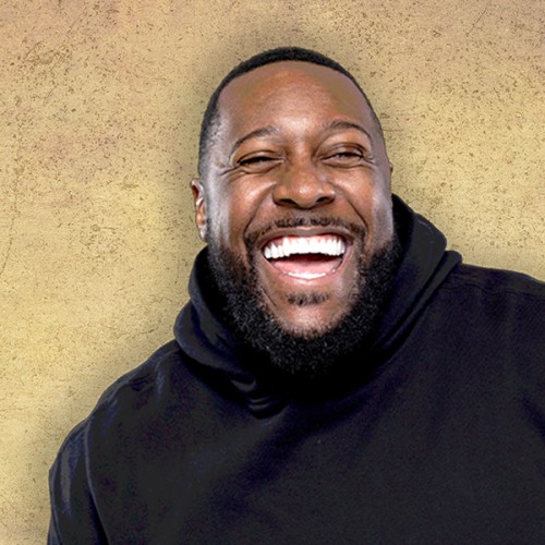 Aurie Styla photographed wearing a black hoodie and laughing.