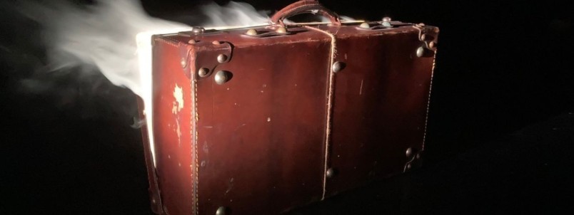 An image of a suitcase on a black background with light behind it