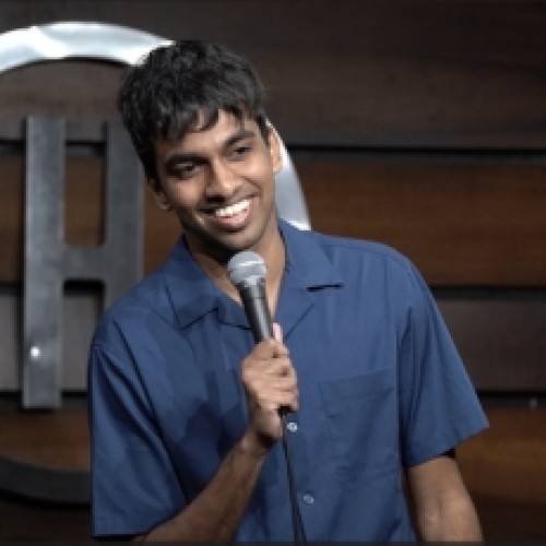 Comedian Tarang Hardikar smiling with his microphone, performing a comedy special