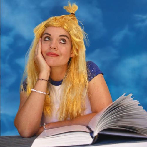An image of Maria Williams in a hillary duff-esque blone wig, looking up to the sky leaning her head on her hand, diary in front of her.