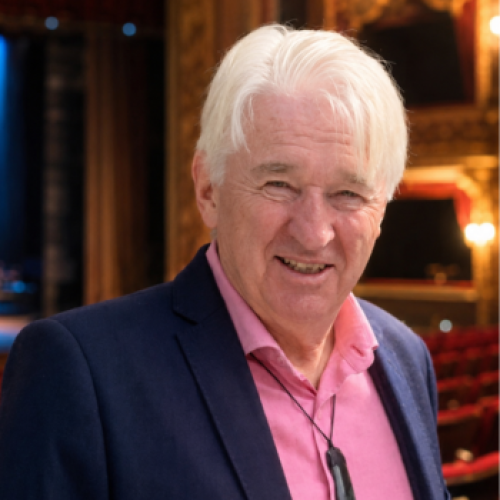 A photo of Tim Dowson inside the Civic Theatre auditorium. Tim is smilingand wears a blue suit.